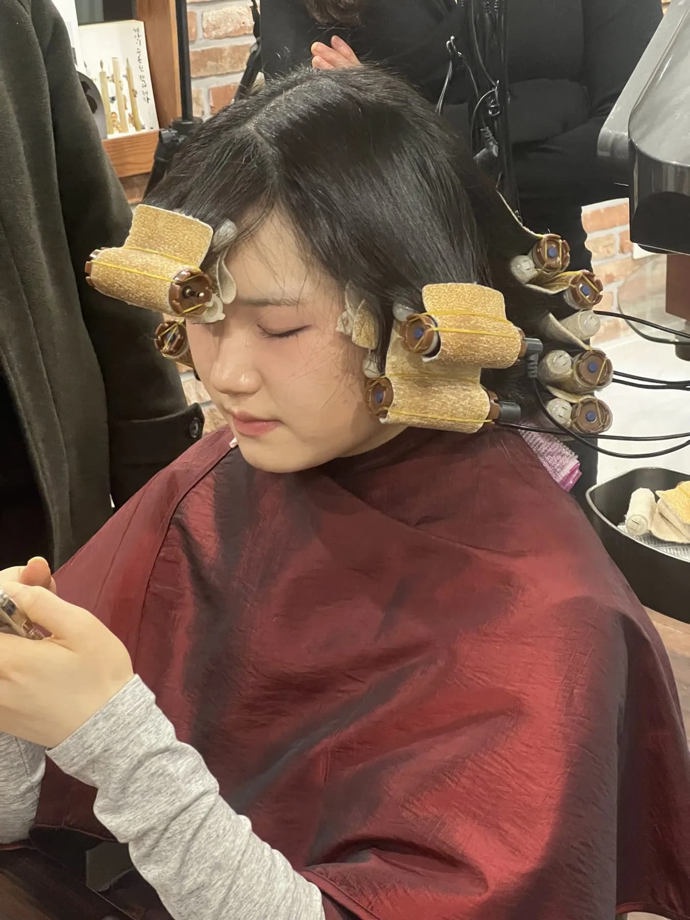 Young woman with heated digital perm rods in her hair