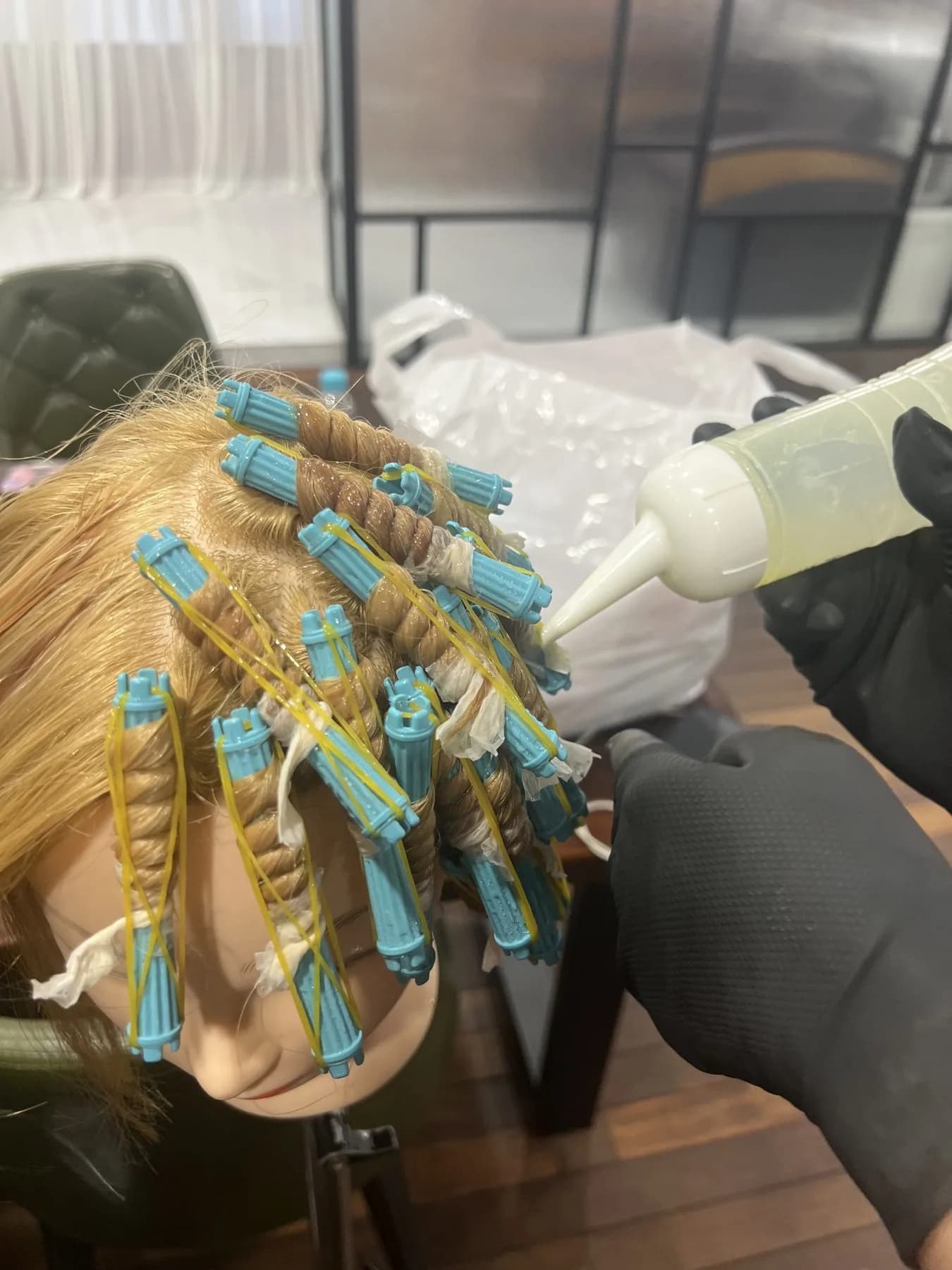 Учебный манекен со светлыми волосами, накрученными на голубые коклюшки