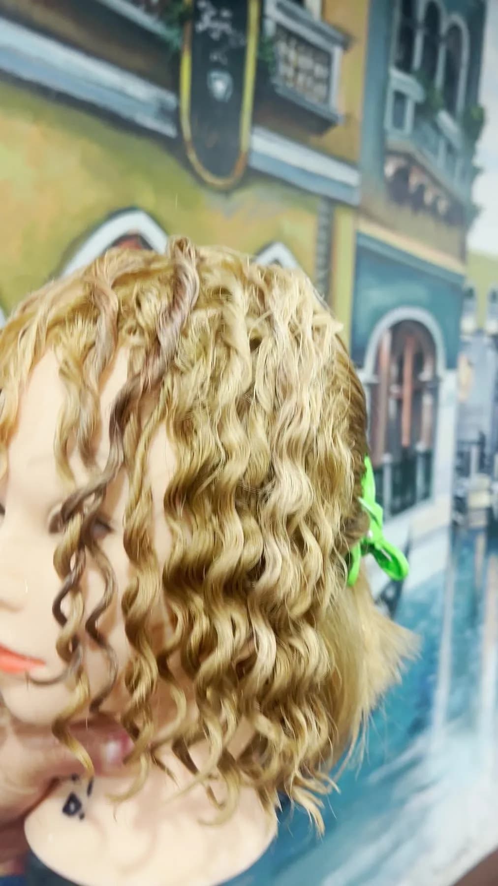 Blonde training head with small spiral curls after a cold perm